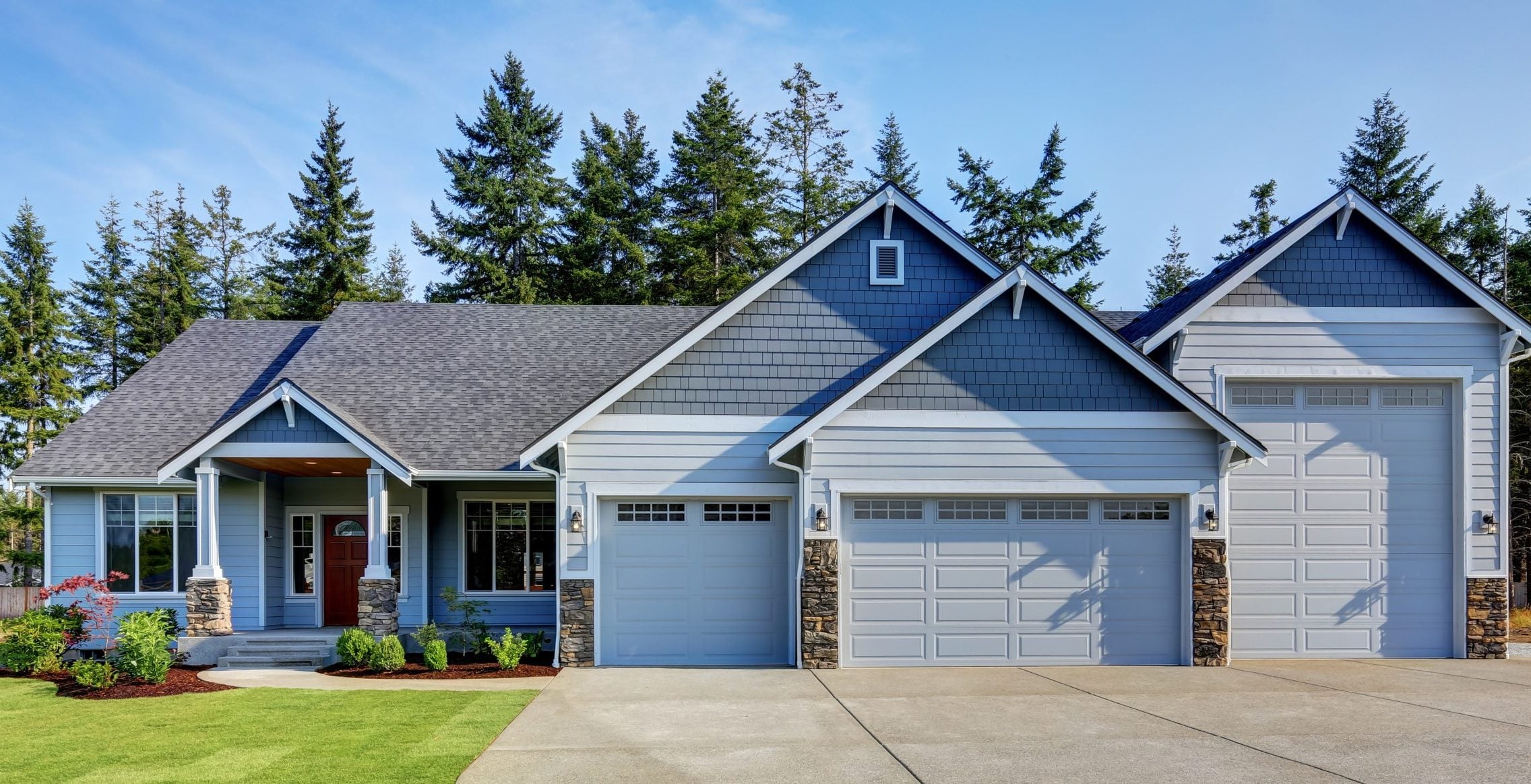 Luxury blue house with curb appeal. Three car garage and long, wide asphalt driveway. Northwest, USA