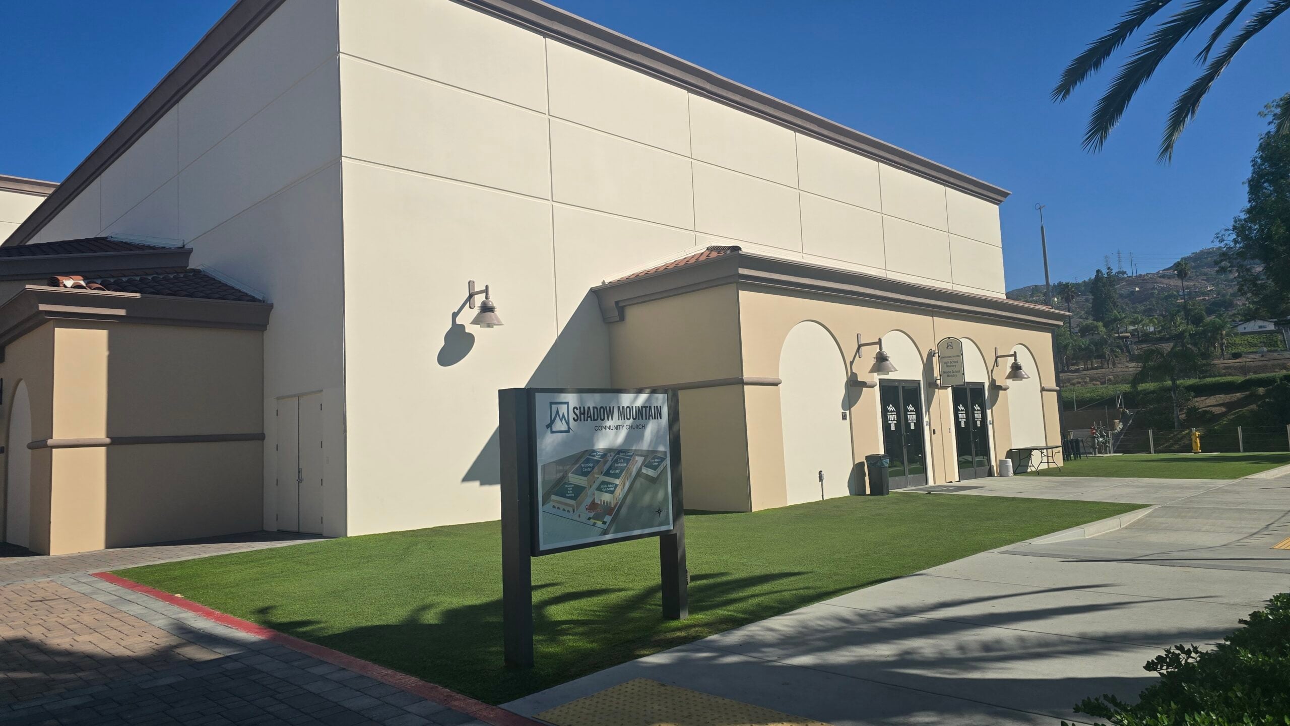 Exterior view of the Shadow Mountain Community Church building with a front sign and green lawn.