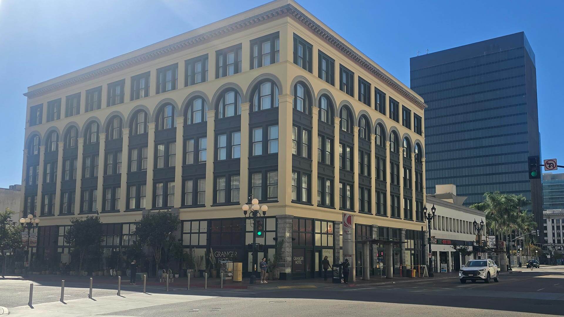 Exterior of the historic multi-story Granger Hotel building at a city intersection on a sunny day.