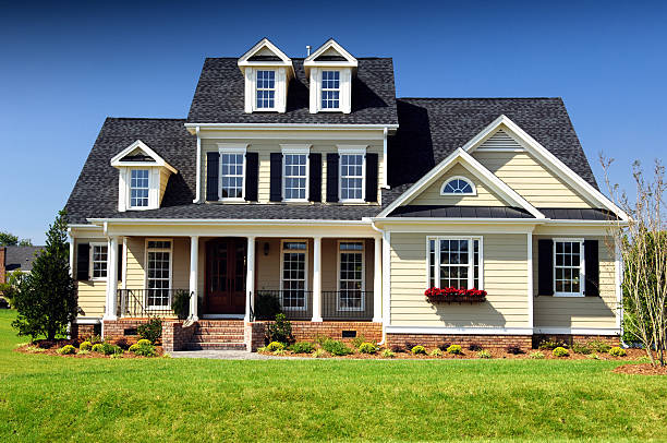 Warm cream exterior paint with crisp white trim, black shutters, and dark roof finishes by a house painter in San Diego, CA